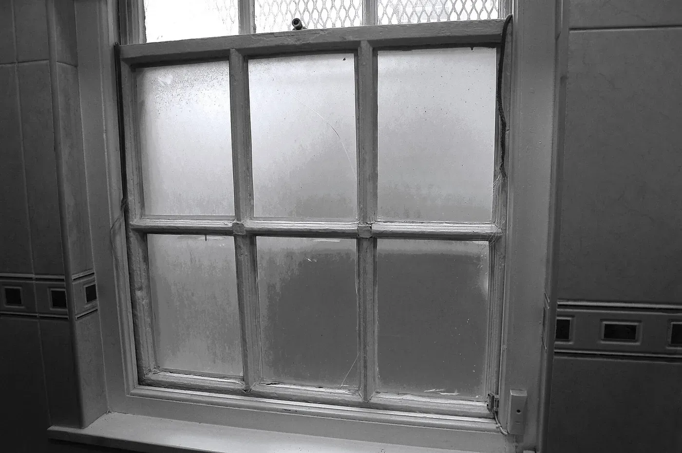 A Georgian timber sash window with glazing bars set in a brick wall
